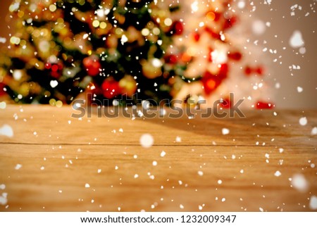 Snow falling against close-up of wooden table