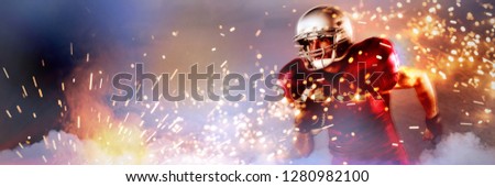 Determined American football player holding ball against firework bursting sparkle background