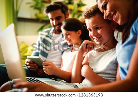 Happy family using laptop and digital tablet in the living room at home