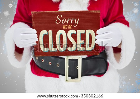 Mid section of santa claus holding page against vintage closed sign