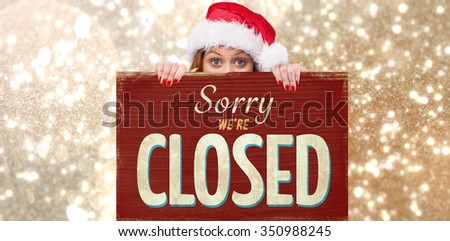 Festive redhead smiling at camera holding poster against vintage closed sign