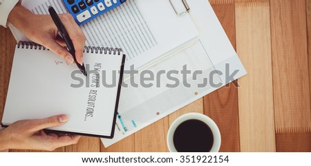 New years resolution list against cropped image of woman writing on notepad