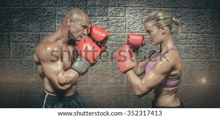 Side view of boxers with fighting stance against grey brick wall