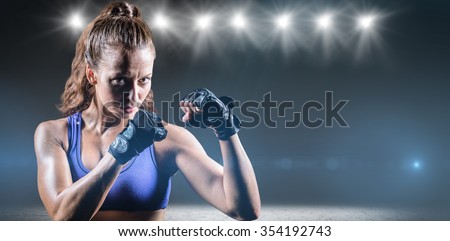 Portrait of female confident boxer with fighting stance against desert landscape