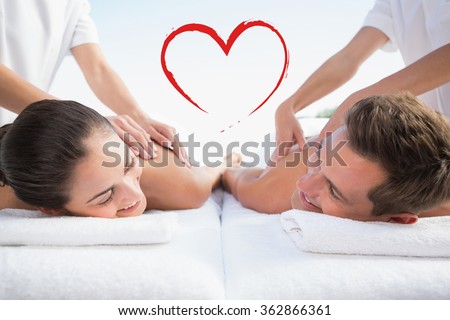Peaceful couple enjoying couples massage poolside against heart