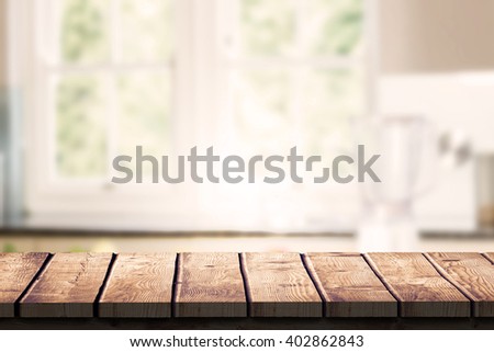 Wooden desk against empty kitchen with vegetables