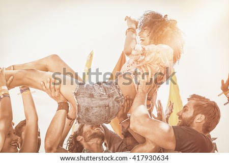 Happy hipster woman crowd surfing at a music festival