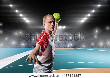 Sportsman throwing a ball against handball field indoor