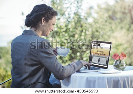 Composite image of build website interface against pretty businesswoman using laptop and having coffee