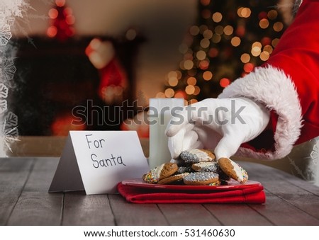 Hand of santa claus putting Christmas cookies on table