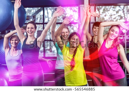 Fit group dancing and smiling in gym