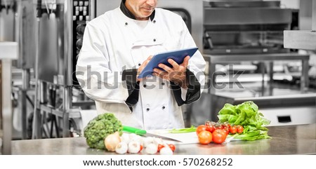 Chef preparing recipe with digital tablet in the kitchen