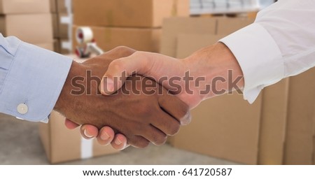 Digital composite of Business people shaking hands in warehouse