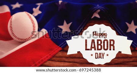Happy labor day text in banner against baseball on american flag at table