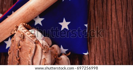 Close-up of baseball bat and gloves on American flag