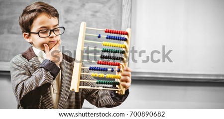 Pupil dressed up as teacher holding abacus in classroom