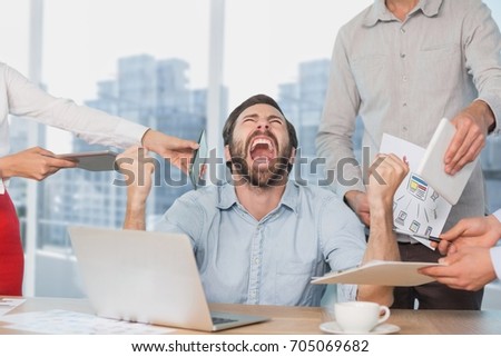 Digital composite of Frustrated business man at a desk yelling