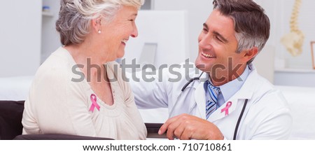 Breast cancer awareness message against male doctor looking at female patient