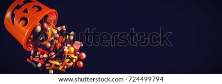 High angle view of bucket with various sweet food over black background