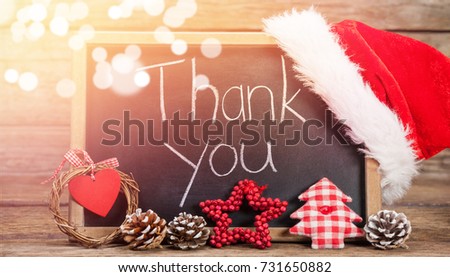 Thank you text on slate with decorations on wooden table during Christmas time