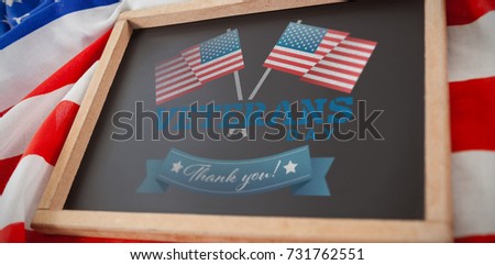 Logo for veterans day in america  against empty slate over american flag  on table