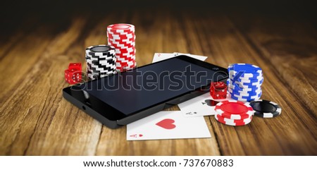 Mobile phone with casino tokens and playing cards against wooden table