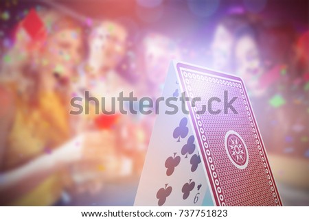 Composite 3D image of happy friends with cocktails against digital composite image of card castle