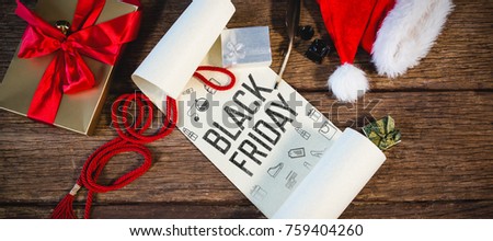 Black friday advert against wrapped gift, santa hat, diary and quill pen on wooden table in living room
