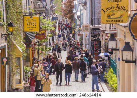 QUEBEC CITY, QUEBEC, CANADA - MAY 29, 2004:  Tourism on Petit Champlain Street, in Old Quebec City. People walk along the narrow street shopping for souvenirs.