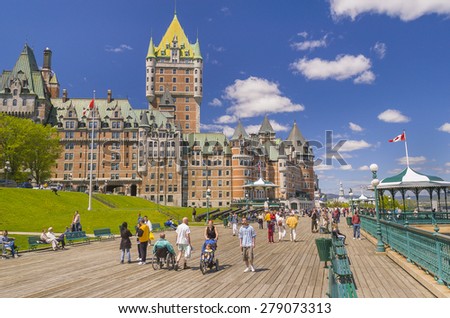 QUEBEC CITY, QUEBEC, CANADA -  MAY 30, 2004: Le Chateau Frontenac castle and hotel, with people walking along Dufferin Terrace boardwalk, a National Historic Site, in Old Quebec City.