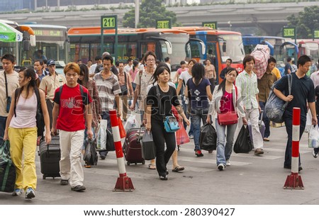 GUANGZHOU, GUANGDONG PROVINCE, CHINA - OCTOBER 12, 2006: Crowd of people disembark buses at train station in city of Guangzhou.