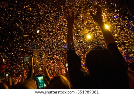 shiny confetti during the concert and the crowd of spectators with their hands up