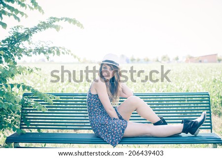 A beautiful young woman, enjoying spare time in a warm spring afternoon, with vintage-like effects.