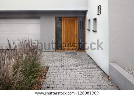 detail of entrance to a new house with garden ornamental grass and pavement