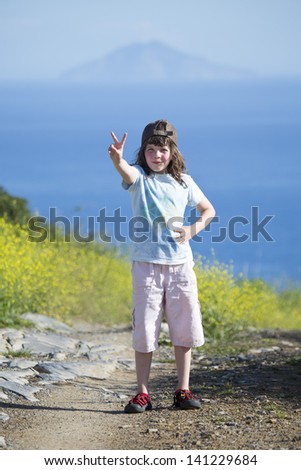 Girl on the path shows victory symbol