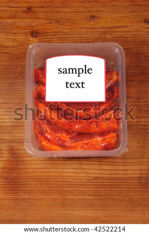 meat in vacuum packing isolated on wood board with sticker