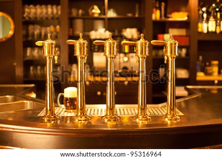 Luxury gold beer spigot at the brewery with a glass of beer