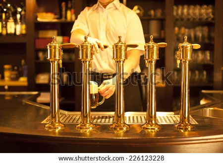 gold beer in the hand and beer taps