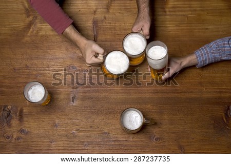 beer and hand at the wooden table