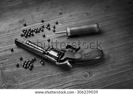 percussion pistol revolver on the wooden table still life with powder box and lead