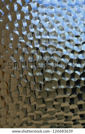 Textured glass panel with strong highlights and deep shadows