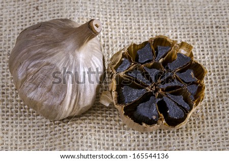 Black garlic bulb with cross section showing black cloves