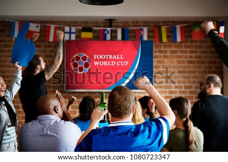 Cheerful supporters watching football at the pub