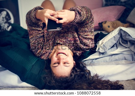 Teenage girl using a smartphone on a bed social media and addiction concept