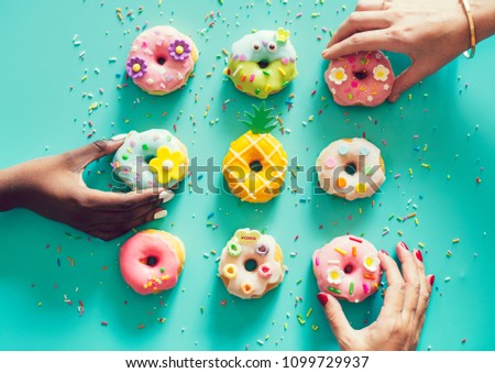 Aerial view of hands picking donuts