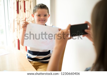 Little boy showing off his drawing