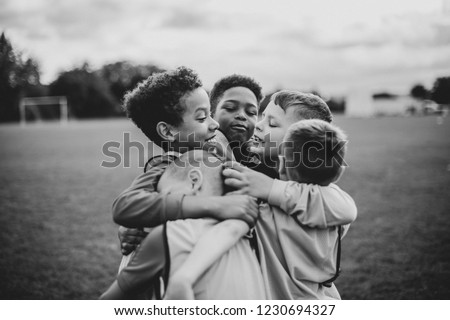 Junior football team hugging each other