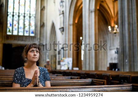 Catholic woman praying with a rosary at the church