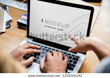 Business people working on a laptop with a screen mockup
