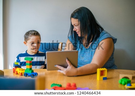 Mother teaching son from a tablet